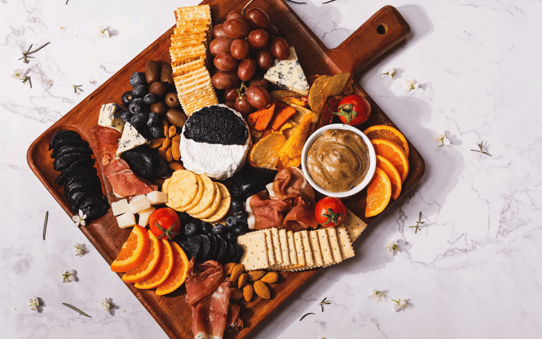 Tabla de aperitivos con ajo negro de la Patagonia Chilena, prosciutto, quesos y crackers